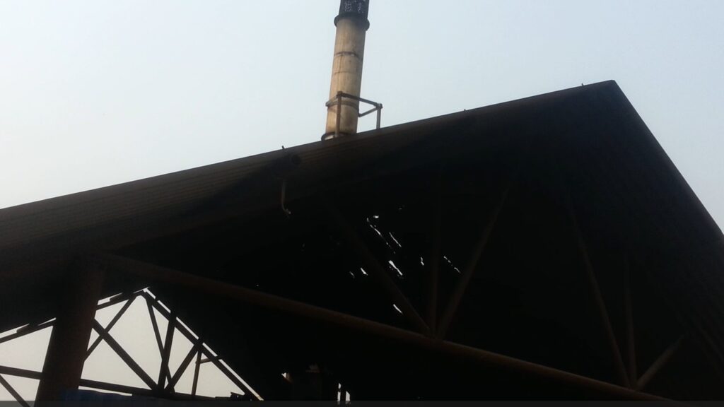 An exhaust stack rises from the roof of the incineration plant facility